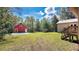 Wide shot of the backyard showing a red barn, green grass and steps to the back door at 16318 Hamilton Dr, Orlando, FL 32833