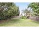 Large, fenced backyard with a tropical palm tree, shade trees, and a decorative bird bath at 1975 Staunton Ave, Winter Park, FL 32789