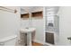 Small bathroom with a pedestal sink, open wood shelving, and access to another small room at 1975 Staunton Ave, Winter Park, FL 32789