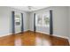 Bright bedroom featuring hardwood floors, large windows, and blue floral curtains, offering a cozy and inviting space at 1975 Staunton Ave, Winter Park, FL 32789