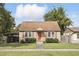 Charming single-story home with a well-manicured lawn, complemented by a quaint orange front door at 1975 Staunton Ave, Winter Park, FL 32789