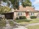 Charming single-story home with a well-manicured lawn, complemented by a quaint orange front door at 1975 Staunton Ave, Winter Park, FL 32789