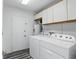 This laundry room has a washer, dryer, cabinets, and water heater at 1975 Staunton Ave, Winter Park, FL 32789