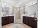 Bathroom featuring double vanities, tiled floors, and a glass-enclosed shower at 2056 Switch Grass Cir, Ocoee, FL 34761