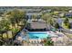 Aerial view of a community pool with lounge chairs, palm trees, and nearby buildings at 2056 Switch Grass Cir, Ocoee, FL 34761