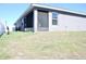 Grey house featuring a screened-in patio overlooking the backyard and blue skies at 2294 Sunset Way, Davenport, FL 33837