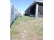 Backyard view of a grey house with a screened-in patio and white fence in the distance at 2294 Sunset Way, Davenport, FL 33837