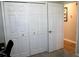 Bedroom closet features white bifold doors and an adjacent door with a silver handle at 2294 Sunset Way, Davenport, FL 33837