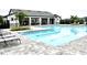 Community pool featuring a paved deck with lounge chairs, surrounded by well-maintained landscaping and a clubhouse at 2294 Sunset Way, Davenport, FL 33837