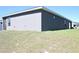 Exterior view of the house with grey siding and a well-maintained lawn at 2294 Sunset Way, Davenport, FL 33837