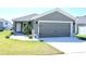 Attractive home showcasing a gray exterior, well-kept lawn, and a convenient two-car garage at 2294 Sunset Way, Davenport, FL 33837