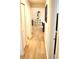 View of a hall with wooden floors leading to a living room with a decorative mirror at 2294 Sunset Way, Davenport, FL 33837