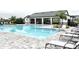 Community pool featuring a pool house, clear blue water, and pool-side seating and lounge chairs at 2294 Sunset Way, Davenport, FL 33837