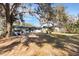 View of the home's backyard featuring mature trees and green space at 2303 Mahoney Ave, Leesburg, FL 34748