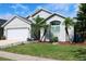 View of home featuring garage, palm trees, and landscaping at 2511 Crown Ridge Cir, Kissimmee, FL 34744