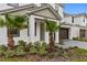 Lovely landscaping featuring palm trees and shrubbery along the facade of a two-story home at 2626 Calistoga Ave, Kissimmee, FL 34741