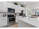 Close-up of a kitchen featuring stainless steel appliances and quartz countertops at 2626 Calistoga Ave, Kissimmee, FL 34741