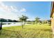 Green backyard leads up to a pond with neighborhood houses in the background at 2706 Vermillion Ct, St Cloud, FL 34771