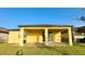 A covered back patio features a brick ground, tan pillars, and a ceiling fan at 2706 Vermillion Ct, St Cloud, FL 34771