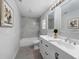 Modern bathroom featuring double sinks, white cabinets, and a bathtub with tiled wall surround at 2730 W Highland St, Lakeland, FL 33815