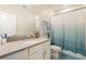 Full bathroom includes a large mirror, and a shower with blue curtain at 2929 Satire St, Kissimmee, FL 34746