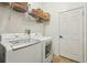 Laundry room with white front-loading washer and dryer, wire shelving, and a white door at 2958 Willow Bay Ter, Casselberry, FL 32707