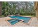 Beautiful pool area featuring lush landscaping, waterfall feature, and hot tub at 2958 Willow Bay Ter, Casselberry, FL 32707