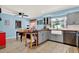 Bright kitchen and dining area with gray cabinets, a farmhouse sink, and tile flooring at 30 Cornwall Ct, Casselberry, FL 32707