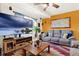 Comfortable living room with a large TV, neutral-toned sofa, and rustic wooden coffee table at 30 Cornwall Ct, Casselberry, FL 32707