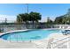 Community pool with palm trees in the background, framed by a white fence and blue sky at 3162 Sun Lake Ct # B, Kissimmee, FL 34747