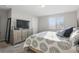 Well-lit bedroom features a decorative bedspread, complemented by matching furniture, TV, and a large window at 319 Smugglers Way, Apopka, FL 32712