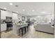 Open-concept kitchen flowing into the living area, featuring modern appliances and a large island with barstool seating at 319 Smugglers Way, Apopka, FL 32712