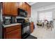 Well-lit kitchen featuring wood cabinetry, black appliances, and breakfast nook with natural light at 409 Hilgard Cv # 106, Sanford, FL 32771