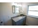 Bright bathroom featuring a vanity with granite countertop, undermount sink and window with natural light at 4452 Fairview Ave, Orlando, FL 32804