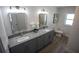 Bright bathroom showcasing a double vanity with gray cabinets, granite countertops and a toilet at 4452 Fairview Ave, Orlando, FL 32804