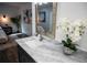 Close-up of the modern bathroom vanity featuring marble countertop and decorative mirror with floral accent at 4452 Fairview Ave, Orlando, FL 32804