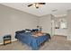 Bedroom with a ceiling fan, neutral walls, and a view into the attached bathroom at 451 Hunter Cir, Kissimmee, FL 34758