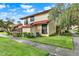 A well-maintained exterior of a townhome with landscaped grounds and a sidewalk at 451 Hunter Cir, Kissimmee, FL 34758