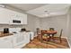 Well-lit kitchen featuring white cabinetry, dining table, and hardwood floors at 451 Hunter Cir, Kissimmee, FL 34758