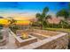 Beautiful backyard fire pit with stone seating and lush landscaping, perfect for outdoor entertaining at 480 Muirfield Loop, Reunion, FL 34747