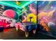 Fun game room with air hockey and colorful space mural on walls at 480 Muirfield Loop, Reunion, FL 34747