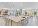 Open-concept kitchen featuring a large center island, stainless steel appliances, and modern pendant lighting at 480 Muirfield Loop, Reunion, FL 34747