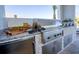 Outdoor kitchen with stainless steel grill, granite countertop, and brick accents at 480 Muirfield Loop, Reunion, FL 34747