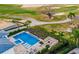 Aerial shot of a modern pool with lounge chairs, a spa, and a fire pit overlooking a golf course at 480 Muirfield Loop, Reunion, FL 34747