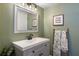 Cozy powder room featuring gray vanity, a mirror and decorative ladder with a soft towel at 509 Shane Cir, Winter Springs, FL 32708