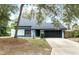 Charming light blue single-Gathering home featuring a black garage door and tidy front yard at 509 Shane Cir, Winter Springs, FL 32708