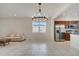 Open-concept dining area with a modern chandelier, stainless steel appliances, and tile floors at 5095 Caspian St, St Cloud, FL 34771