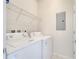 Practical laundry room with washer, dryer, and storage shelving at 5095 Caspian St, St Cloud, FL 34771