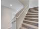 Carpeted staircase with white railings and neutral walls leading to the upper level of the home at 5095 Caspian St, St Cloud, FL 34771