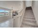 Carpeted staircase with a view of the living room and kitchen at 5095 Caspian St, St Cloud, FL 34771